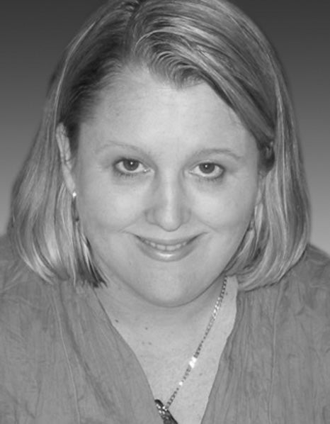 Portrait of a smiling woman with shoulder-length hair in a black and white image.